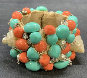 Lucite Coral & Turquoise Statement Bracelet: Vintage coral and turquoise toned lucite bracelet with faux pearl, faux shell, and crystal decoration. Measures approx. 8 inches long, 2 inches wide. Some scratching and chipping observed. Property of