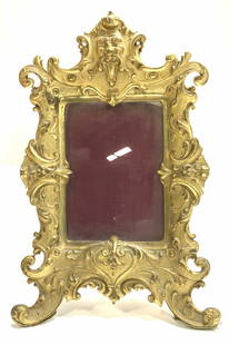 Antique Baroque Gilt Bronze Victorian Table Frame: Heavy ornate Metal table frame, possibly gilt brass or gilt bronze. Victorian acanthus scrolling , heart motif on lower part, Figural head on crown. Picture measurement 5 5/8 in. x 4.25 in., overall s