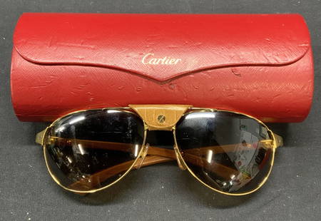 Cartier Santos Dumont Aviator Sunglasses France: Cartier Santos Dumont Collection aviator sunglasses with wood arms, gold tone frame, and croc embossed leather bridge piece. Includes red leather case. Designer label on arm. Made in France. Sunglasse