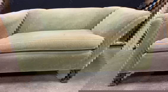 Vintage Green Crushed Velvet Loveseat: A vintage green hued crushed velvet loveseat. One removable seat cushion. Four wooden feet. Two carved front feet. Slightly curled arms. Some discoloration and surface wear present, some losses to woo