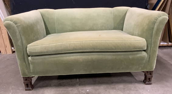 Vintage Green Crushed Velvet Loveseat: A vintage green hued crushed velvet loveseat. One removable seat cushion. Four wooden feet. Two carved front feet. Slightly curled arms. Some discoloration and surface wear present, some losses to woo