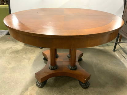 BAKER FURNITURE Neoclassical Style Wood D Table: Table is trademarked BAKER FURNITURE. Piece has circular shape. Dining table is neoclassical style with 4 paw feel. Table appears to be wooden possibly veneer. Table is divided in center. Piece measur