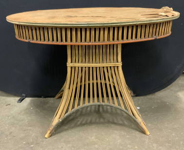 Antique Oval Bamboo Table: Antique oval top bamboo table. Piece is crafted from bamboo and wood. Splay legs. Measures approx. 29.5H x 24D x 42W in. Piece has evident wear. Some discoloration and losses present. Some loose piece