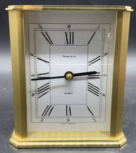 Vintage Tiffany & Co Rectangular Brass Clock: Vintage Tiffany & Co rectangular brass German clock. Clock face reads Tiffany & Co, Quartz, Made in Germany. Reverse opens to reveal a battery pack marked 938 QUARTZ MADE IN GERMANY. Not tested for fu