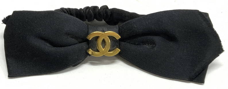 CHANEL CC Black Satin Bow Scrunchie, 1990s France: Vintage circa 1990s Chanel black satin bow scrunchie with gold tone interlocking C hardware. Signed on oblong plaque to underside. Stamped on hardware. Measures approx. 6.5 x 2.25 inches. Made in Fran