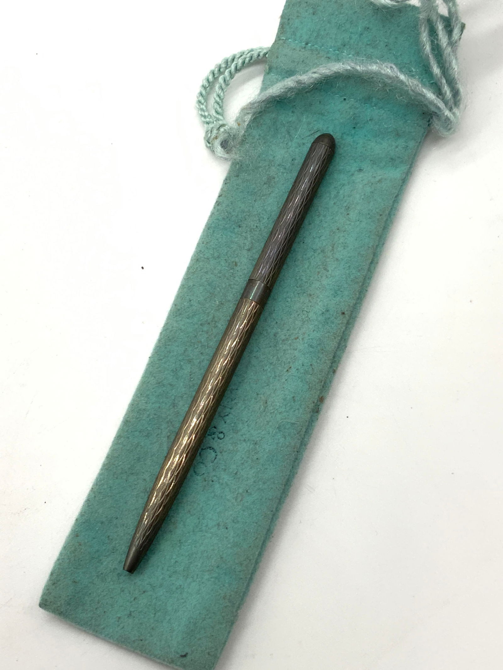TIFFANY & Co Sterling Silver Ballpoint Pen Germany: Marked on pen, Tiffany & Co, 925, Germany. Sterling silver slim retractable ball point pen with diamond shaped etchings on exterior. Comes with Tiffany & Co blue pouch. Pen is approx 5 inches long, po