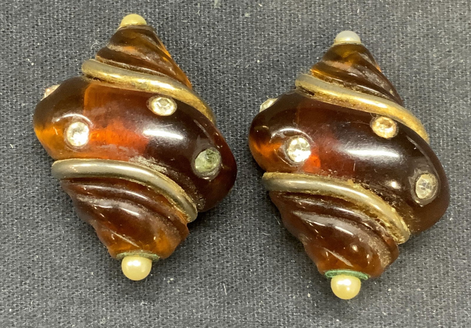 KENNETH LANE Amber Tone Shell Earrings: Vintage Kenneth Lane amber toned lucite shell clip on earrings with crystal decoration. Signed to underside. Measure approx. 1.5 x 1 1/8 inches. Some scratching observed. Property of Manhattan estates
