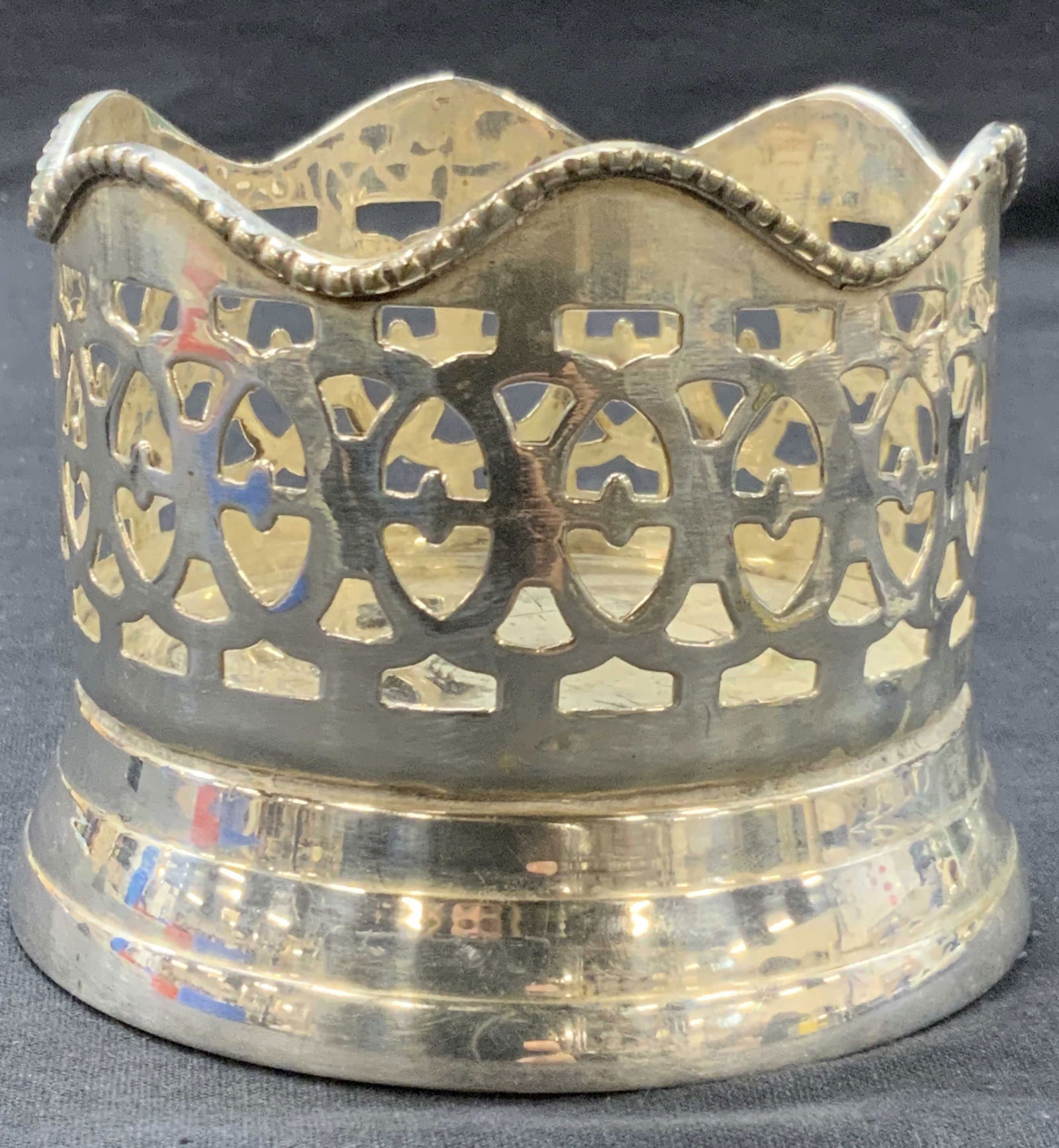 Vintage Silver Plate Bottle Coaster: Vintage silver plate wine bottle coaster with cutout design on edges and wave rim.approximately 3.5 inches tall and 4 inch diameter. Moderate surface wearing, scratches and residue observed Vintage wi