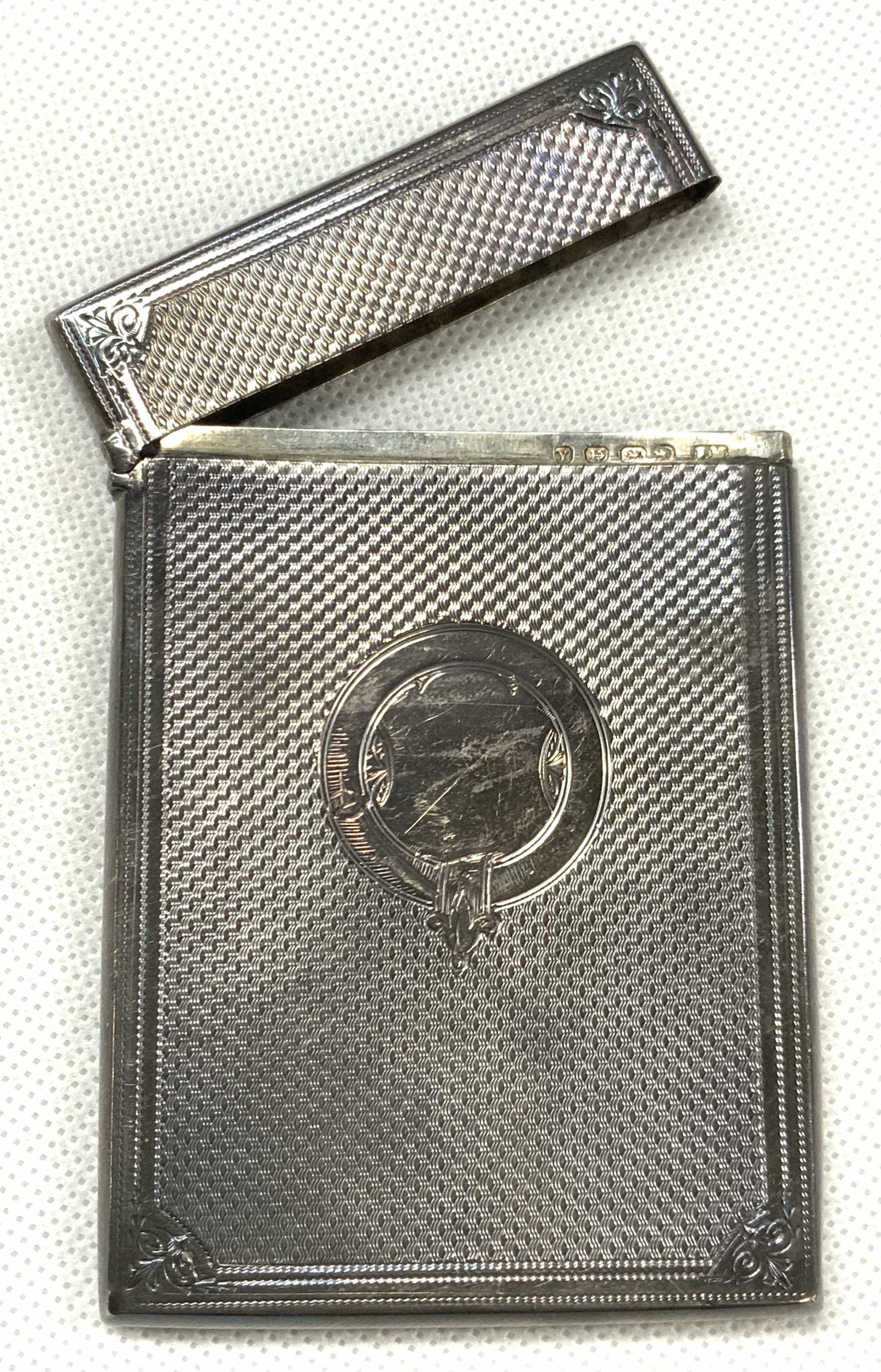 Antq FM Stamped Sterling Silver Card Case: Antique, possibly vintage stamped card case with hinged lid and textured exterior with center etched design. Stamped on inner edge with lion and anchor Passats. Approx 4 x 2.5 inches. Total weight 1.7