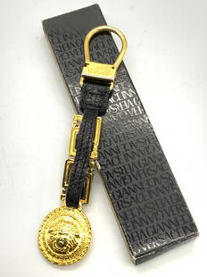 VERSACE Metal & Leather Key Ring W Orig Box: A Key ring made of gold toned metal and black leather, marked on metal Gianni Versace, and adorn with a gold toned Medusa head. Approx 5.25 inches long. Comes with black original box, black and adorn