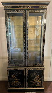 Vntg Asian Chinoiserie China Cabinet: China cabinet is vintage. Piece is black with intricate gold toned chinoiserie detail. Top half has 3 glass shelves. Lower half has lacquered shelf. lower portion has double cabinet doors, separates f