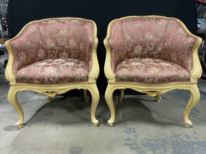 Pair Vintage Louis XV French Armchairs: Lot includes 2 armchairs. Each have cream toned and gilt wooden frames. Upholstery has intricate floral motif detail. Each chair has carved wooden feet. Upholstery has gimp edges. Chairs each measure