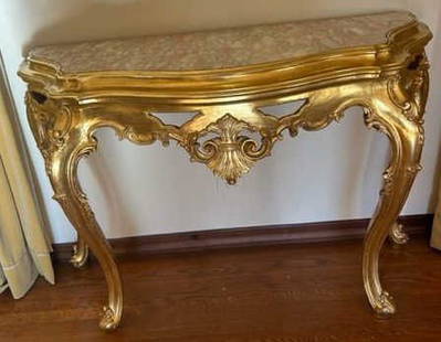 Antique Gilt Wood Console Table W Pink Marble Top: Antique gilt wood console table with a pink marble top. The top features pink, white, and gray hues. Carved woodwork throughout. Curved cabriole style legs. Measures approx. 54W x 17D x 37H in. Some w