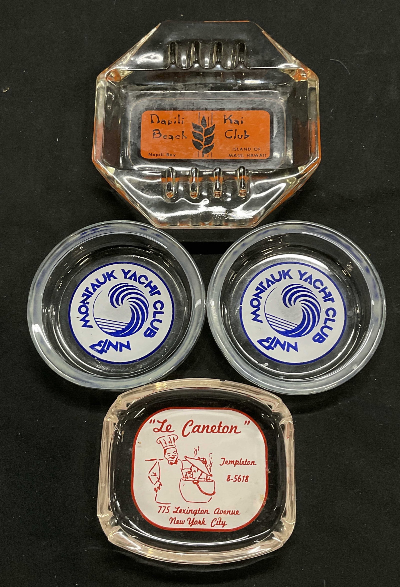 Lot 4 Souvenir Ashtrays Napili Kai Beach Club HI: 4 Souvenir glass Ashtrays. Le Caneton, NYC; Montauk Yacht Club; Napili Kai Beach Club, island of Maui Hawaii. Napili Kai Beach Club Ashtray Measures approx. 5H x 5W in. Some surface wear consistent wi