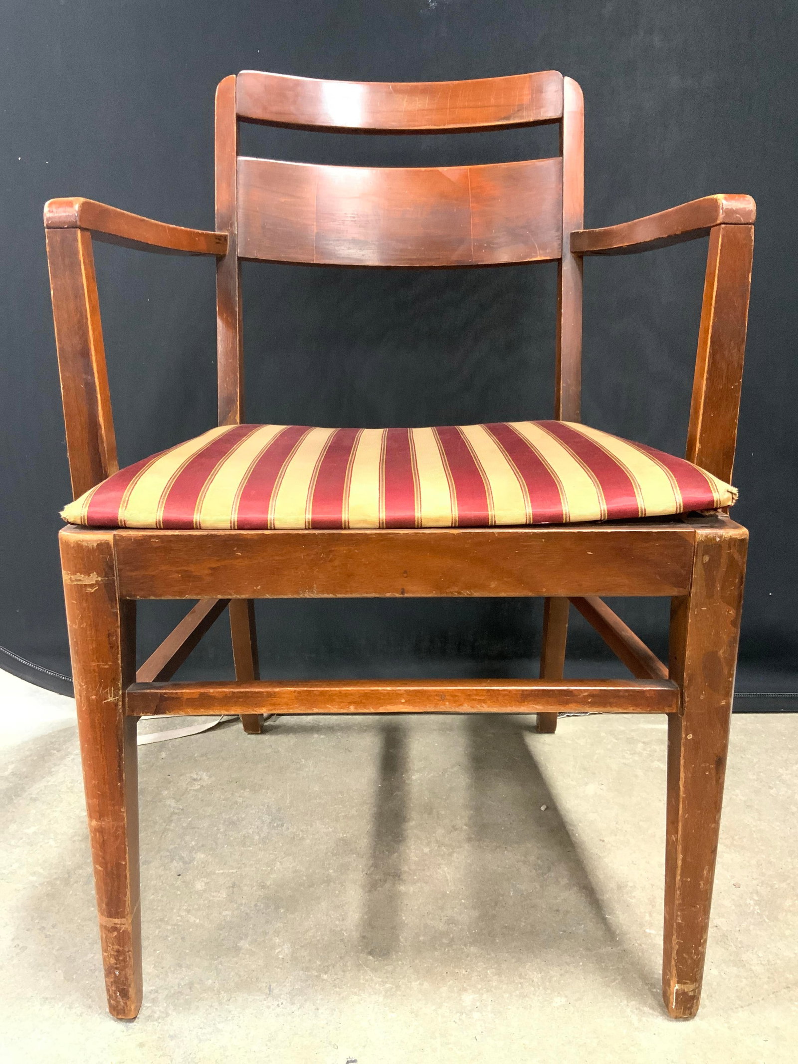Vintage Carved Wooden End Chair W Uph Seat: End chair is vintage and wooden. Piece has red and gold toned upholstered seat cushion. Chair legs have box stet her in between. Chair measures approx 33 inches tall 22 inches wide 23 inches deep. Vin