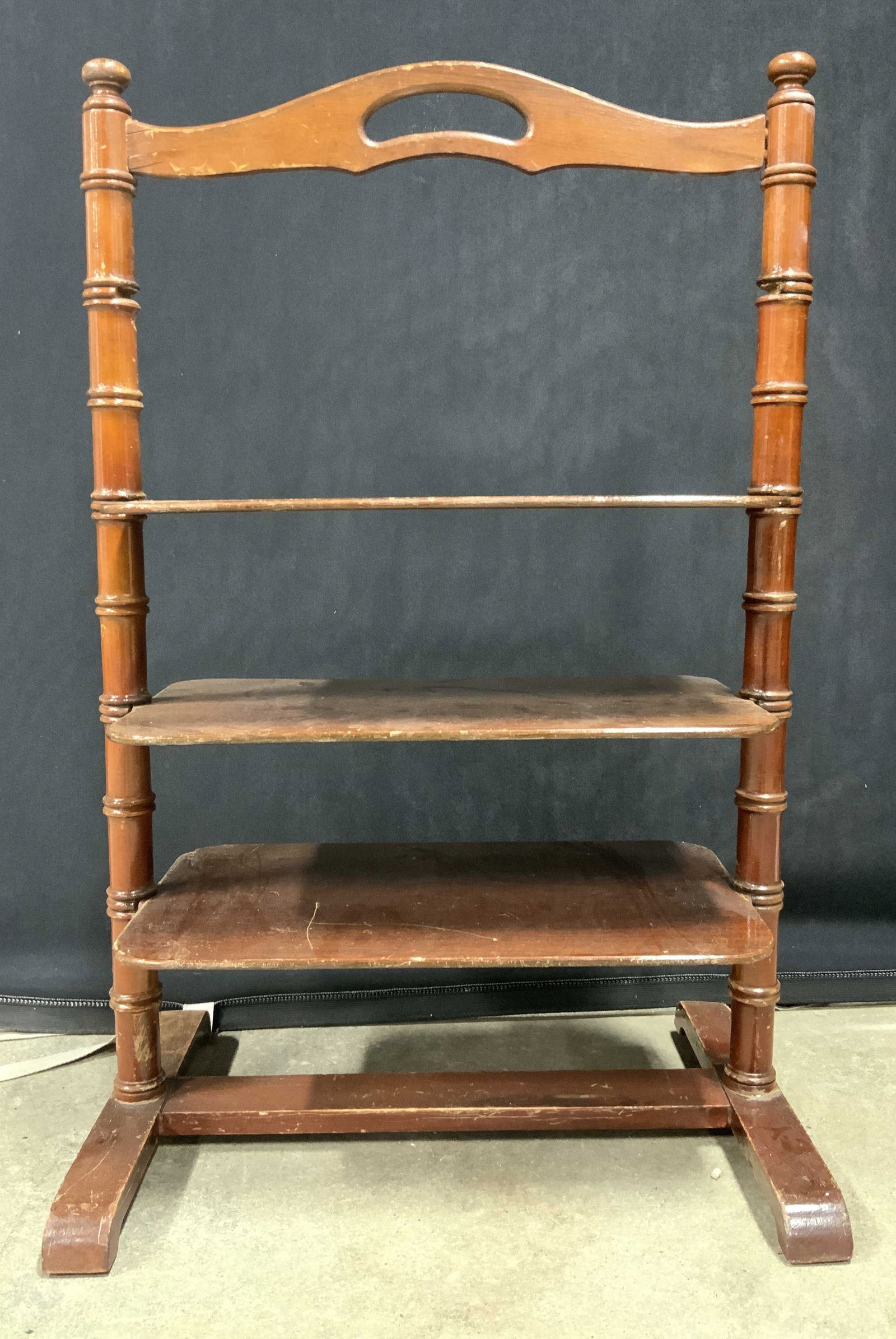 Vintage Carved Wooden 3 Tier Shelf w Handle: Shelf is vintage. Piece has 3 tiers each with rounded rectangular shape. Top of piece has handle. Shelf is brown toned & wooden. Piece measures approx 28 inches tall 18.5 inches wide 12 inches deep. T