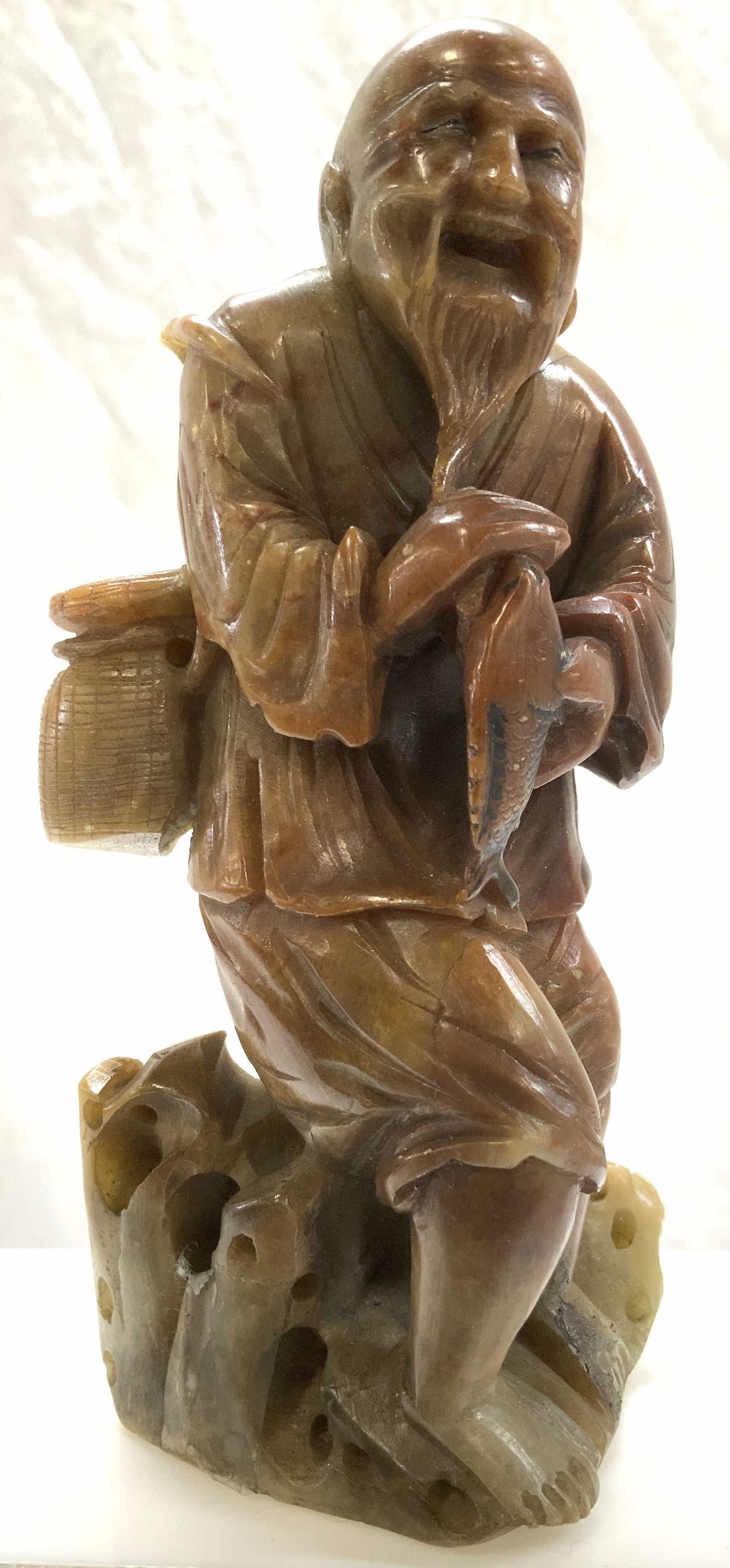 Carved Jadeite Asian Fisherman Figural: Vintage carved mottled green- brown topaz jadeite Asian fisherman figural. Measures 5 x 2.5 in. Backside has missing piece. Tests positive for jadeite , brown parts test positive for topaz on gem test