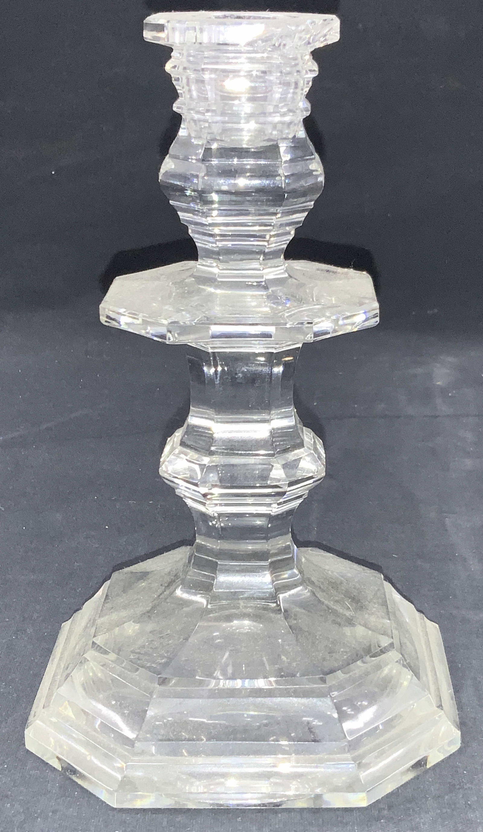 Baccarat Stamped Crystal Candlestick, France: Stamped on underside baccarat France, clear crystal candlestick with faceted sides. Approx 7.5 inches tall and 5 inch wide base. Evident loss to top of candlestick. Baccarat candlestick, Crystal candl