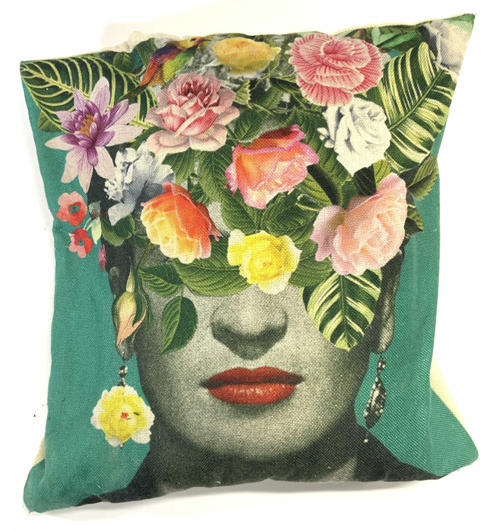 FRIDA Floral Detailed Throw Pillow: Pillow depicts artist FRIDA KAHLO with face covered by multi toned floral & leaf detail. Backside of pillow is cream toned. Pillow appears to possibly be woven canvas. Piece measures approx 16 inches 