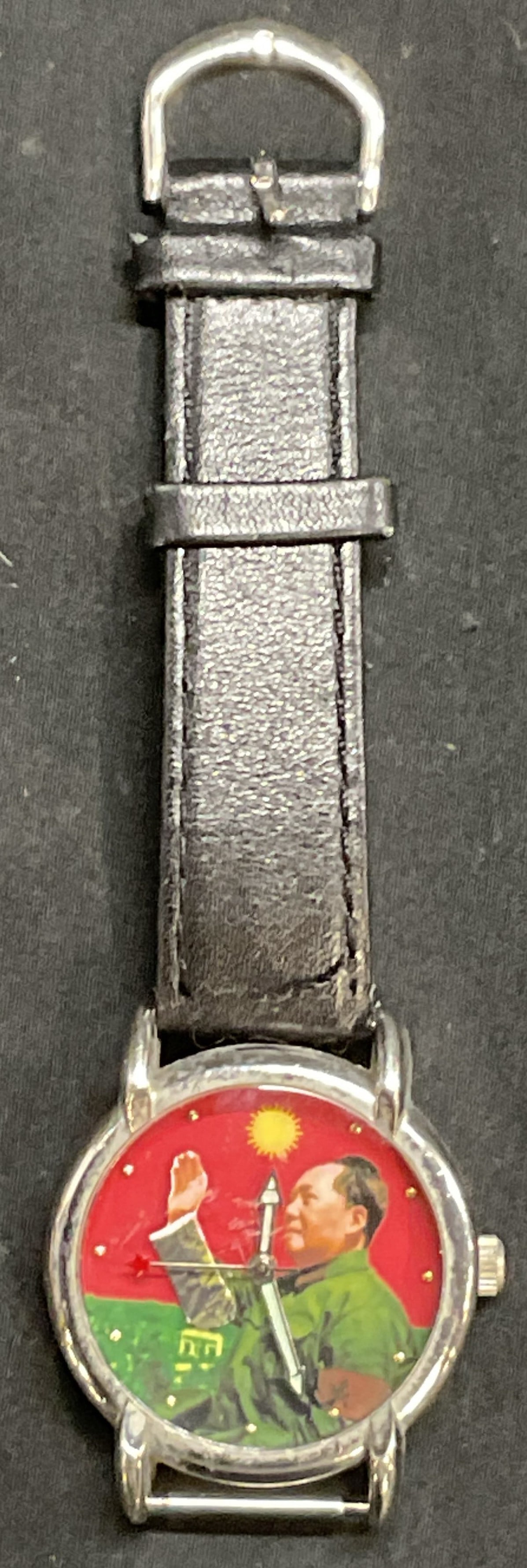 Vintage Chairman Mao Tse-Tung Waving Watch.: Vintage Chairman Mao Tse-Tung Waving Watch with silver hardware. Only has one black leather strap, other half will need to be replaced to become wearable. Watch measures 1 3/4 in by 1 1/2 in. Strap me