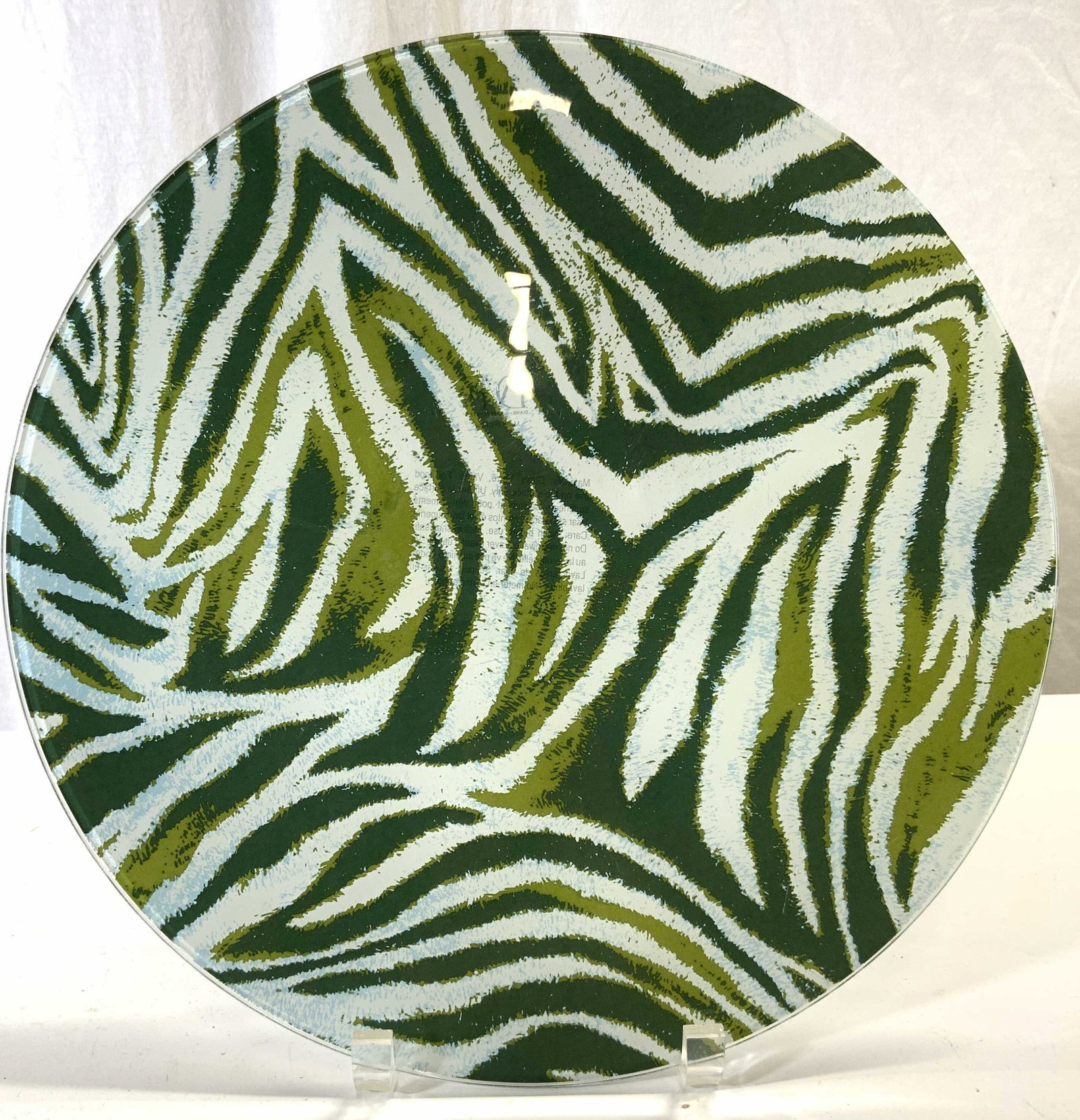 DIANE VON FURSTENBERG Zebra Pattern Glass Charger: Tag on Underside reads DIANE VON FURSTENBERG. Charger is glass with green & white toned zebra stripe pattern detail. Piece measures approx 13 inches diameter. Charger, glass charger, charger plate, gl