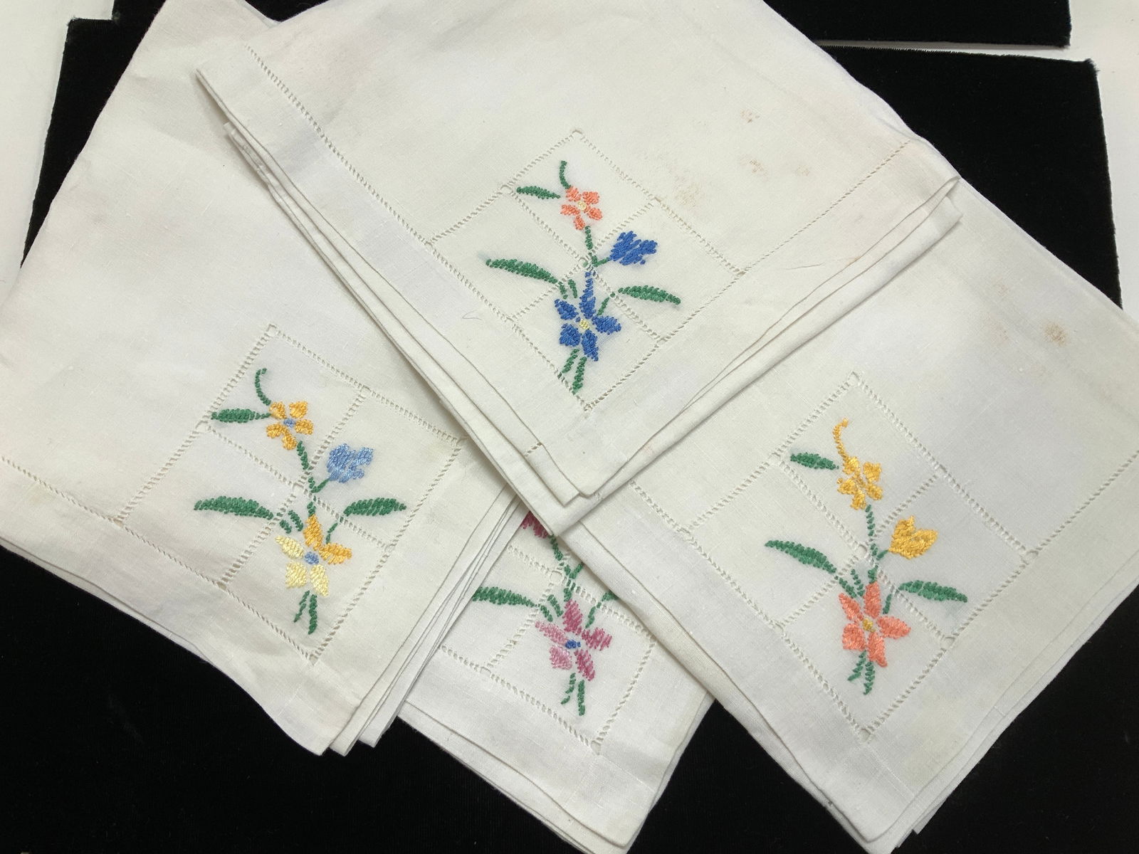 Set 4 White Linen Napkins w Embroid. Flowers: Hand embroidered linen napkins, same flower style in corner with different colored embroidery thread. Napkins measure 22.25 x 22 in. Discoloration consistent with use and exposure. Home linens, vintag