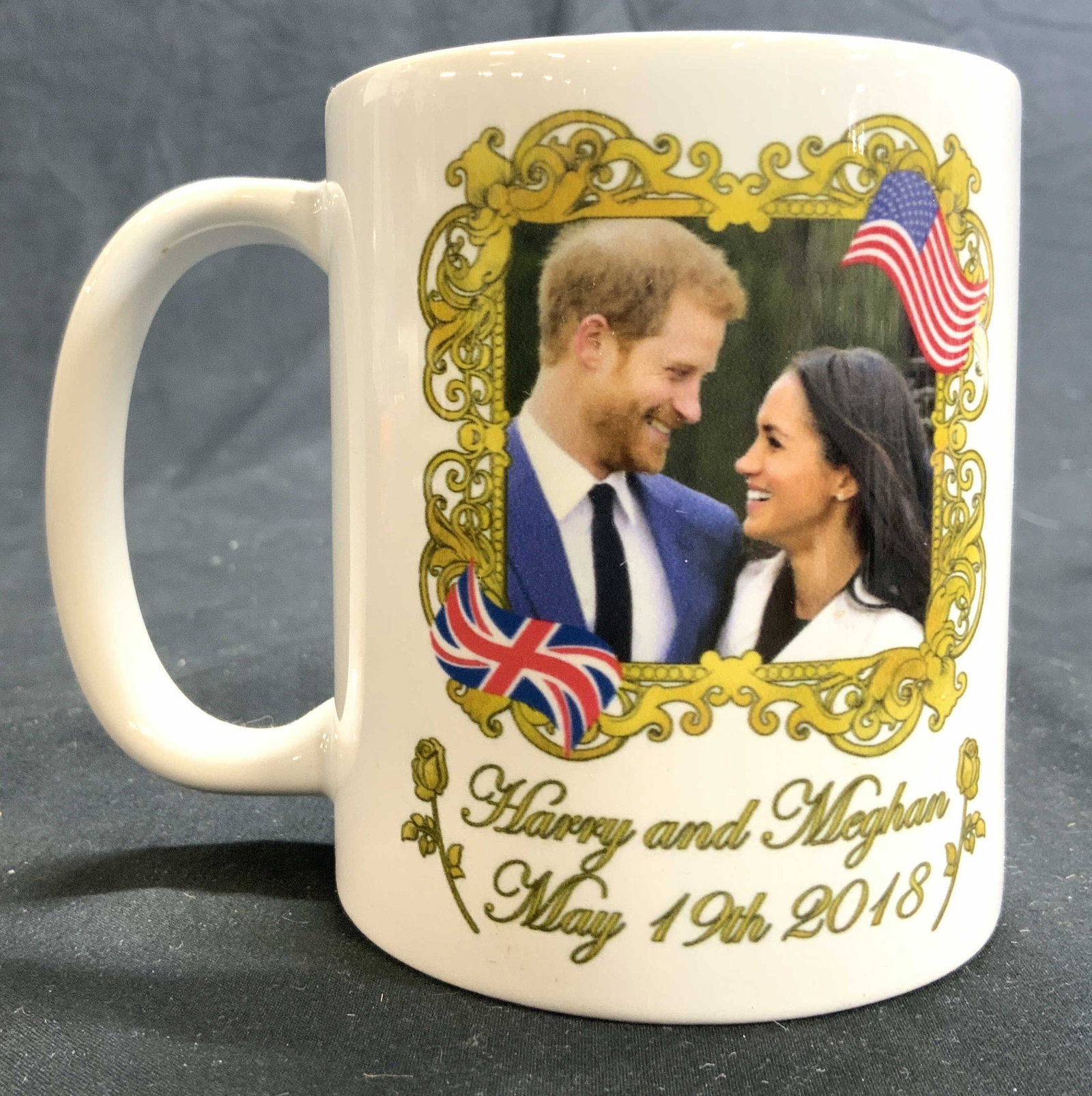 HARRY & MEGAN Porcelain Coffee Cup: Cup reads HARRY AND MEGAN MAY 19TH 2018. Depicts Prince Harry and Megan Markle within ornate frame. Vessel is porcelain. Piece measures approx 4 inches tall 3.25 inches wide 4.5 inches deep. Cup, vess