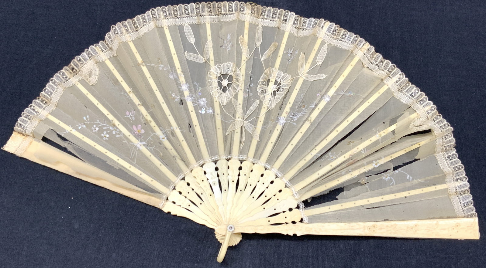 Antique Carved Bone & Lace Hand Painted Hand Fan: Antique hand fan with frame possibly made of carved Bone and with lace and embroidered floral appliques and hand painted flower motifs on frame. Approximately 8 inches long folded and 15 inches long u