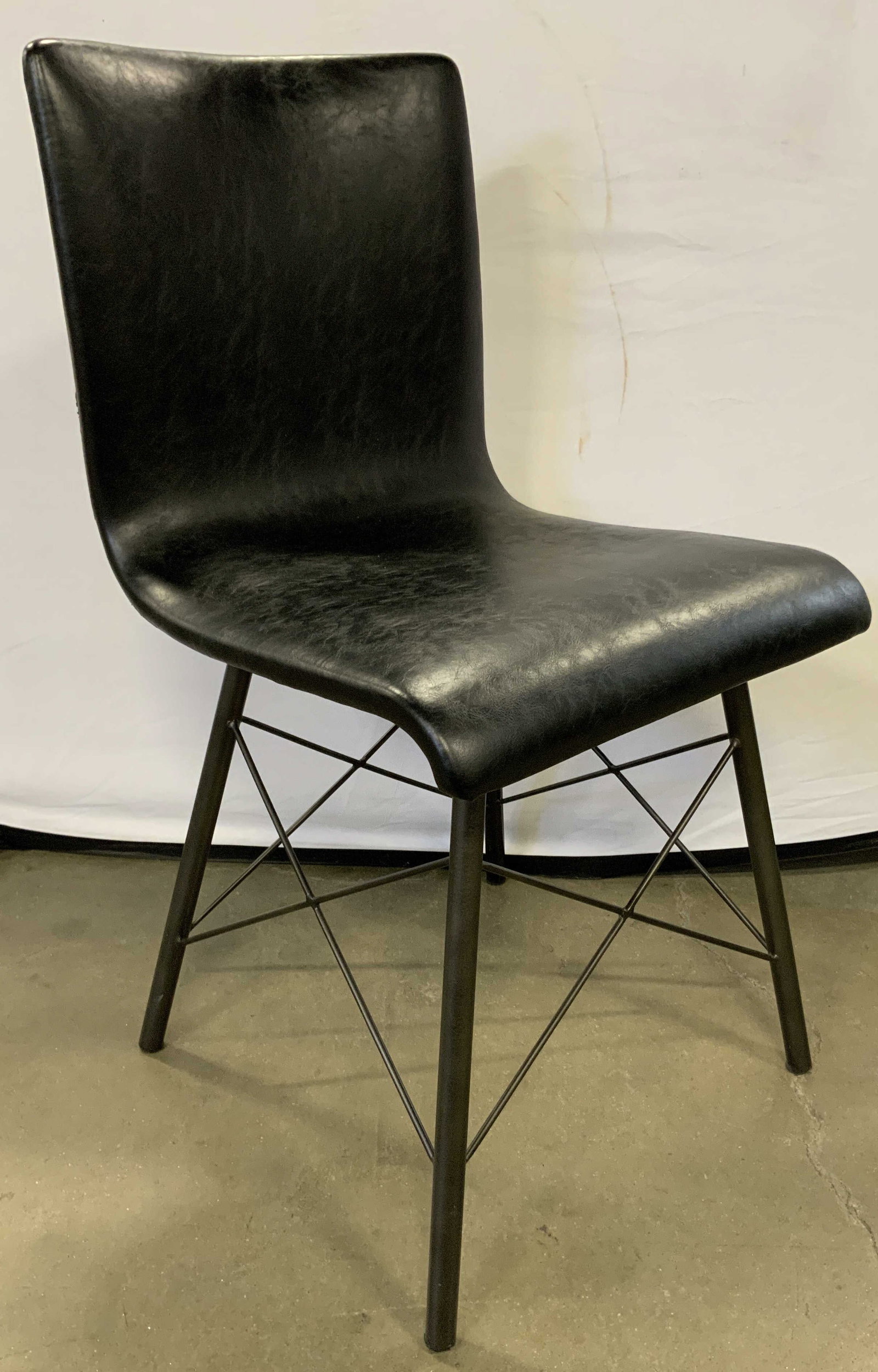 COUNTRY WILLOW Black Leather Side Chair: A black side chair crafted from leather, possibly leather style, material. Black metal base with X form stretchers between the legs. Country Willow tag to underside. Donated by Country Willow Fine Fur