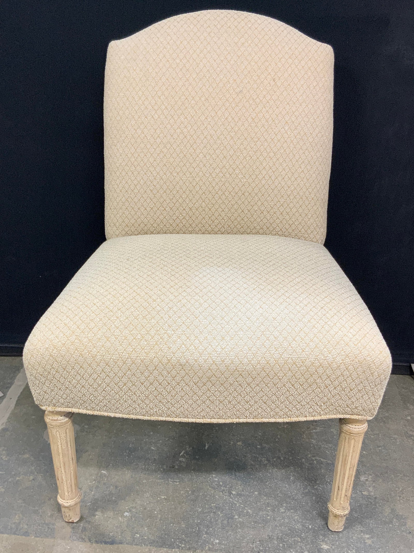 Vintage Upholstered Side Chair: A vintage upholstered side chair with carved wooden legs. Light neutral hue. Diamond pattern to the upholstery. Low seat. Measures approx. 30H x 21W x 19D in. Some separation present. Sone discolorati