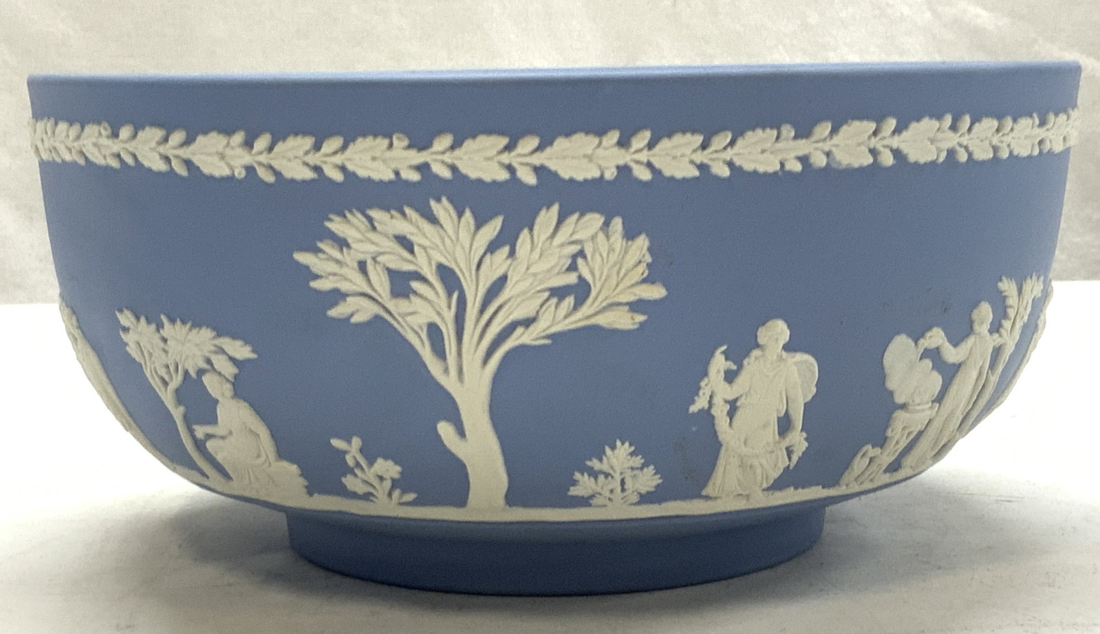 Wedgwood Light Blue Porcelain Bowl, England: Light blue Wedgwood Bowl with embossed neoclassical Laurel. Roman-Greco gods with cherubs. hallmarked : Wedgwood Made in England with impressed numbers 86, 8, & W. Ca. 1986. 8 x 3.75 in. Wedgwood porc