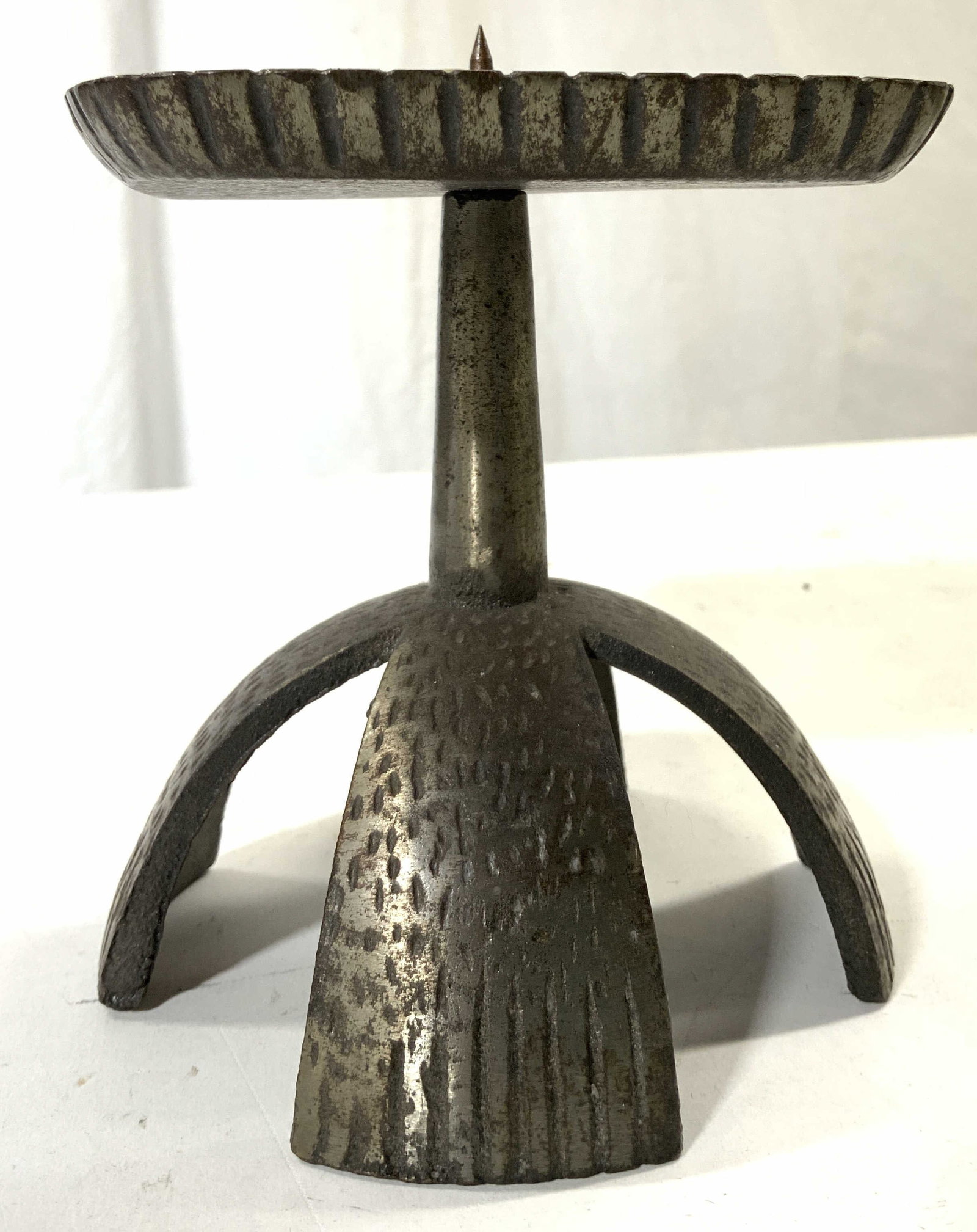 Vintage Footed Pewter Candlestick: Candlestick is vintage. Piece is silver toned appears to be pewter. Candlestick is footed. Piece has spike at top & textured relief detail. Candlestick measures approximately 5.5 inches tall & wide. C