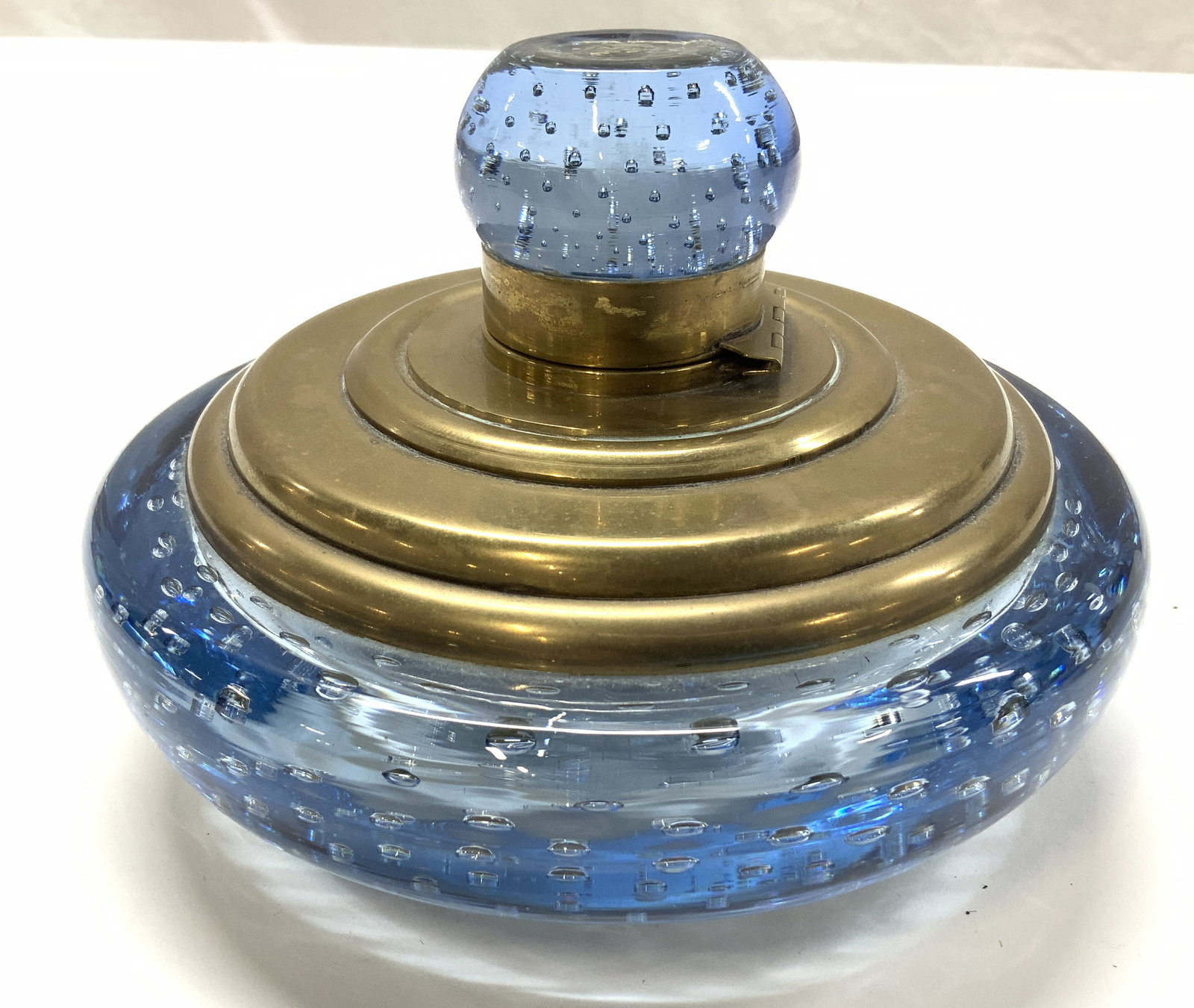 Hand Blown Encased Bubble Glass Ink Well 7in dia: Possibly mid century, circa 1950s. Sapphire Blue Glass Brass Inkwell of Bulbous form, unsigned possibly murano or whitefriars Luxury light blue blown glass with controlled bubble pattern. Brass ink we