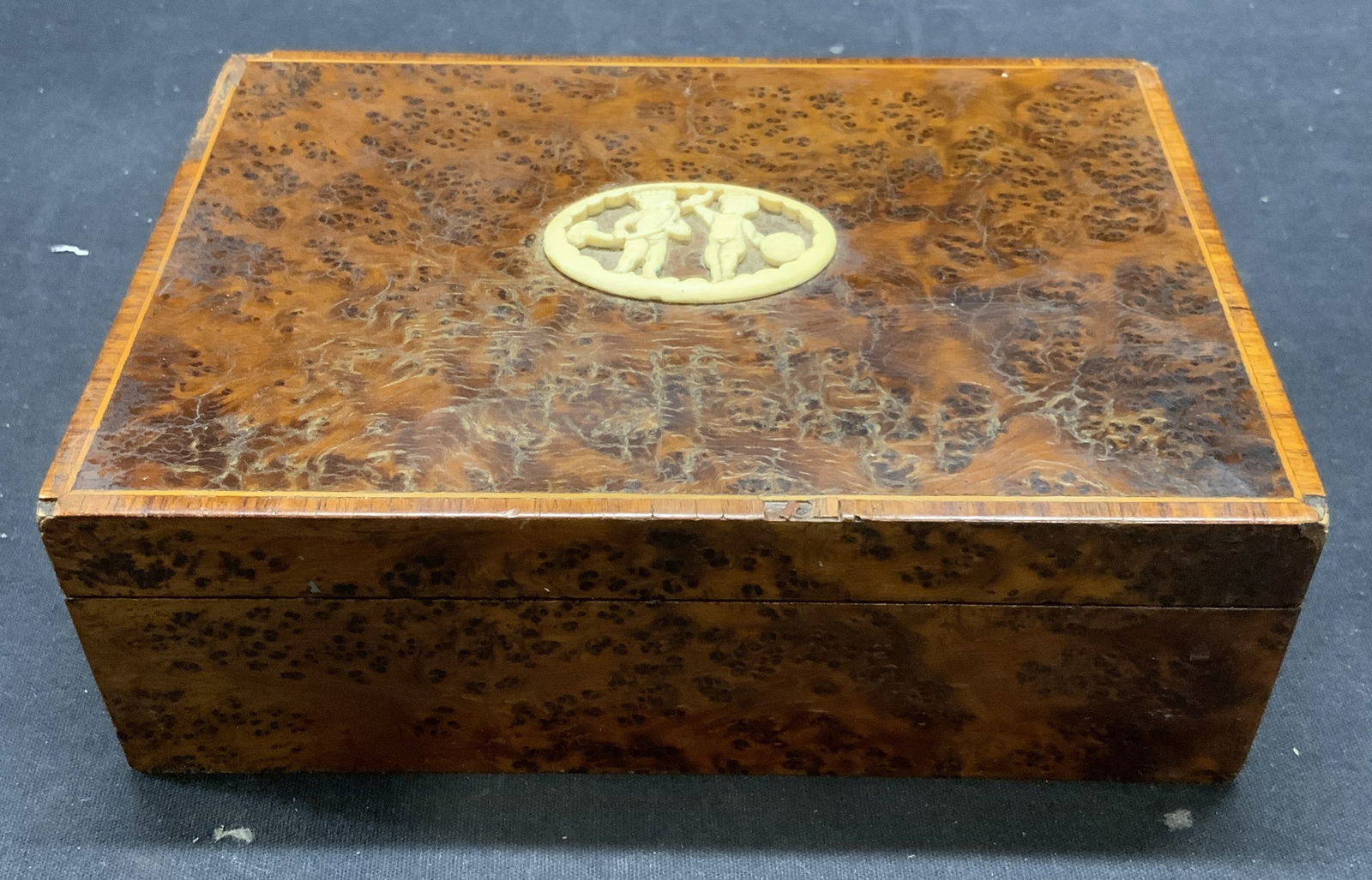 Vintage Burl Wood & Carved Bone Dresser Box: Vintage, possibly antique, possibly 1920s French. Burl wood and carved bone dresser/jewelry box with cherubs playing musical instruments motif, horn and drum. Measures approx. 7 x 5 x 2.25 inches. Som