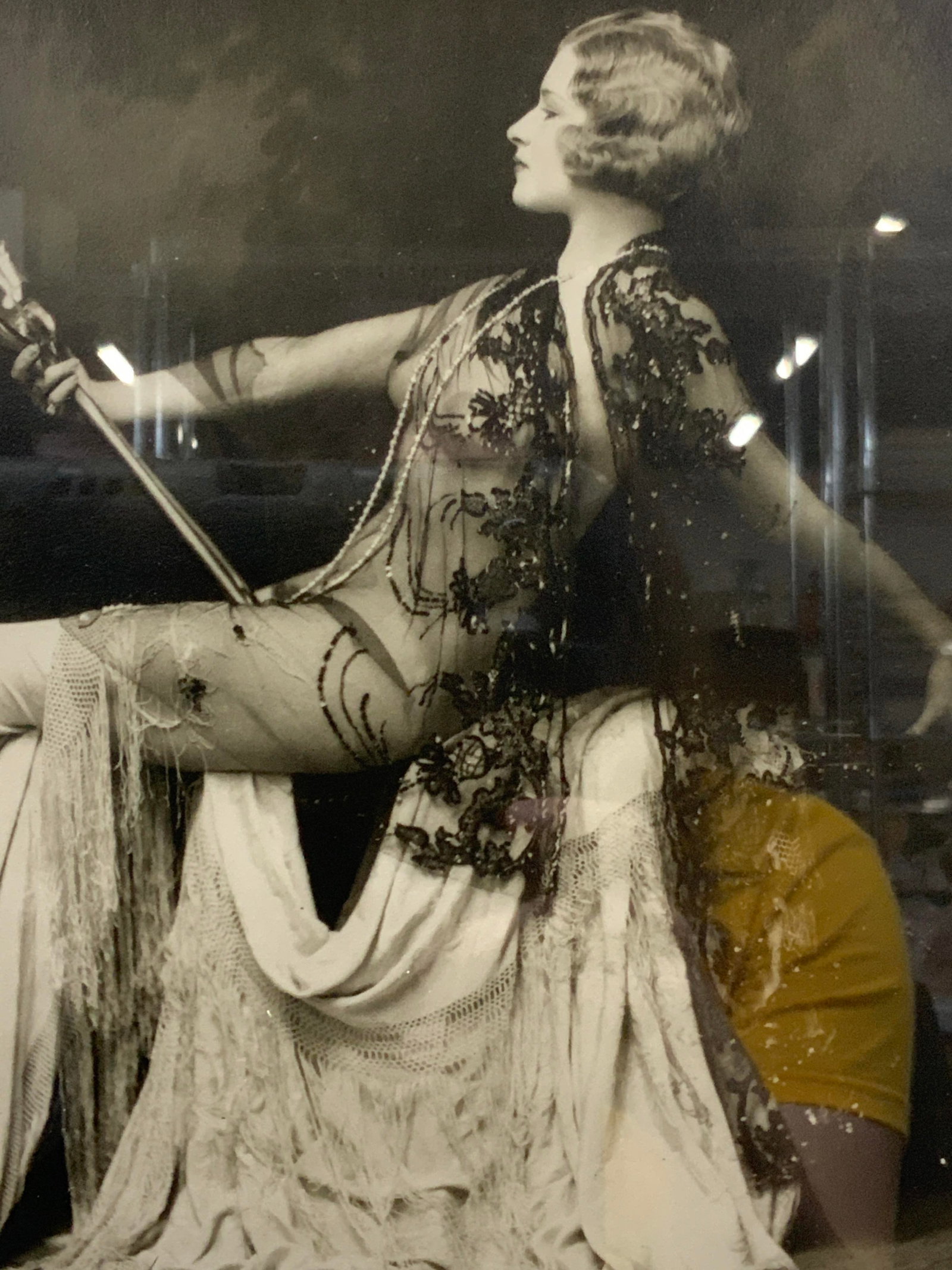 Black & White Vintage Female Photograph: Black and white vintage possibly antique photograph of a nude woman seated with sheer clothing on and drapery around her, she lounges back and holds a mirror in her hand. Framed in a silver leafed woo