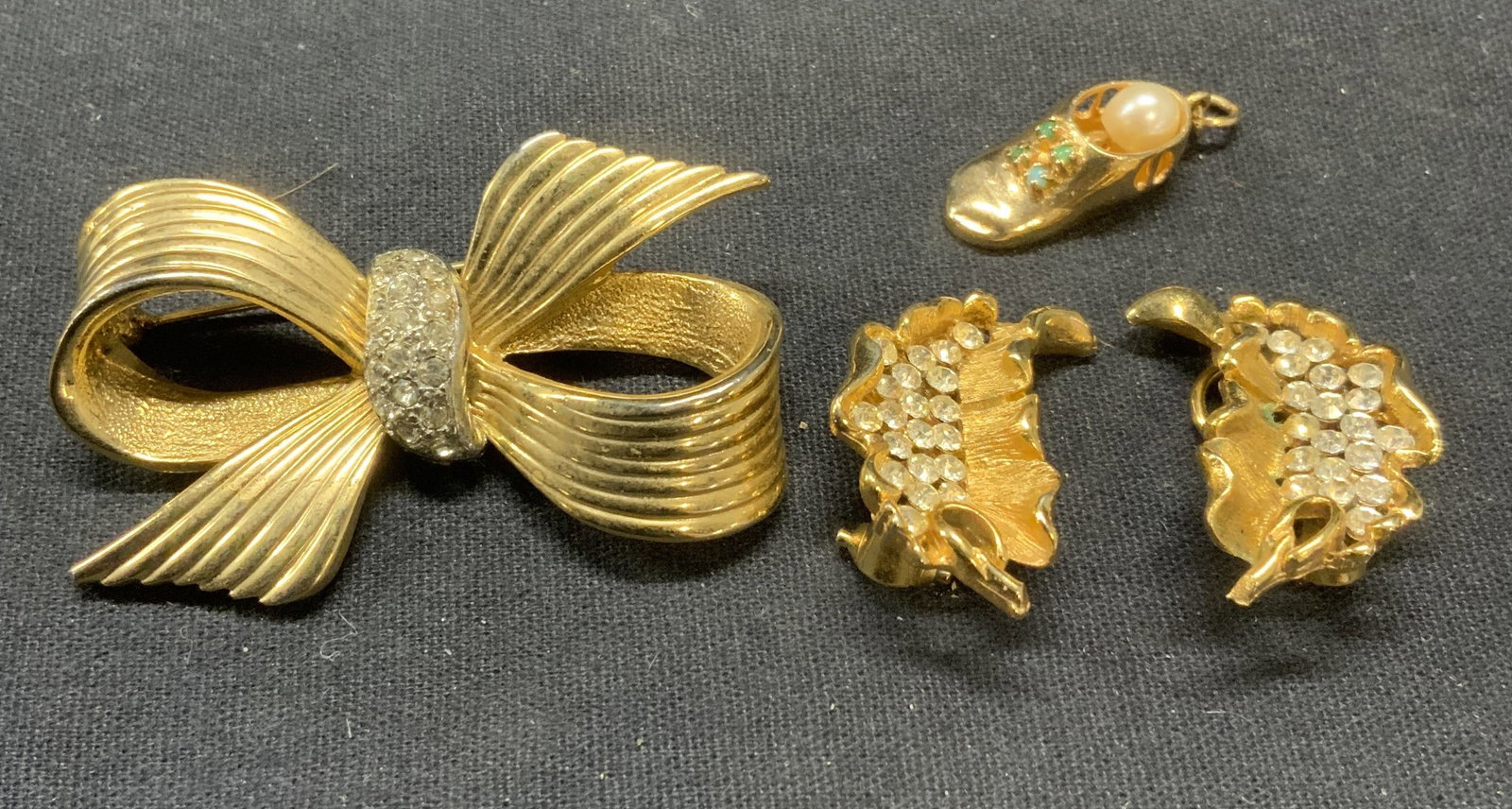 Lot 3 BSK Gold Tn Crystal Earrings, Bow Brooch: Lot of 3 jewelry pieces. Vintage BSK gold tone leaf earrings with colorless crystal decoration. Signed to underside. Clip on backing. Measure approx. 1.25 x .5 inches. Vintage gold tone textured bow b