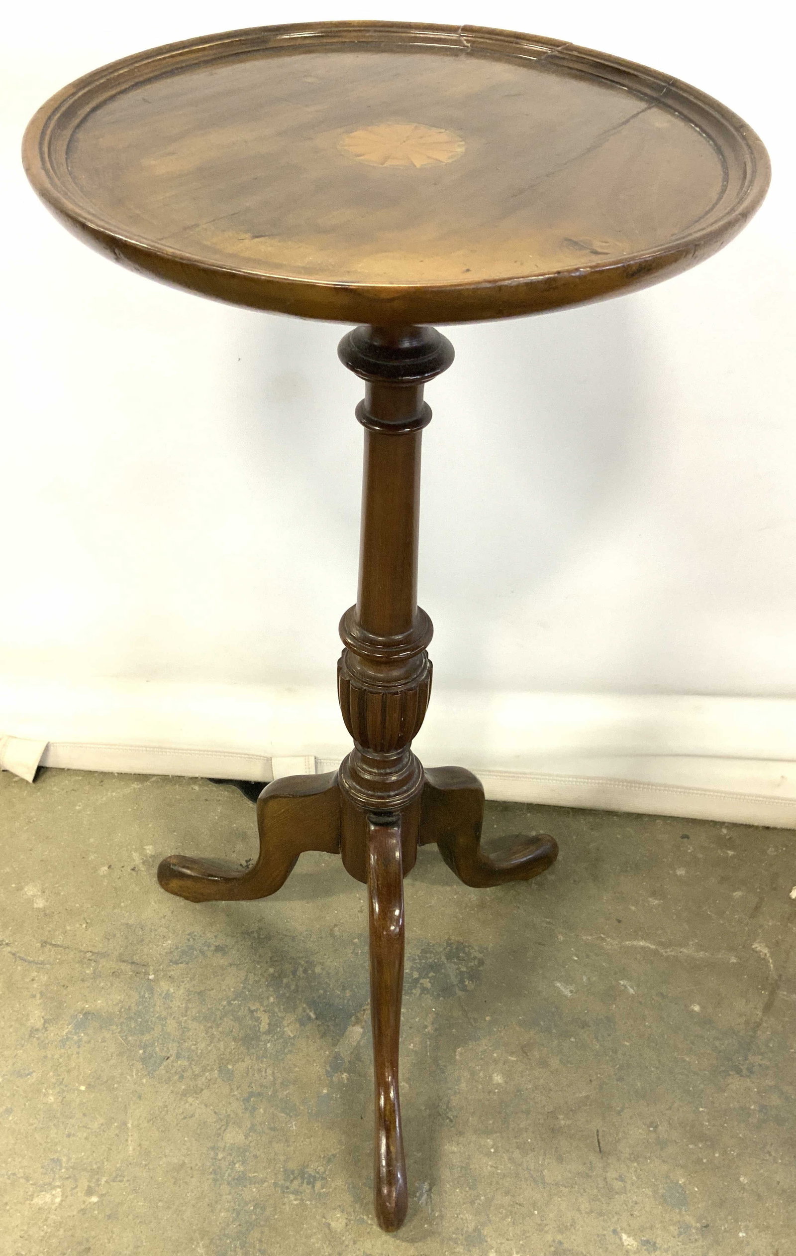 Vintage Wooden Pedestaled Wine Table: Wine table is vintage and wooden. Piece has circular shaped top, pedestaled base with tripod feet. Center of piece appears to possibly have inlay detail. Table measures approximately 22 inches tall 12