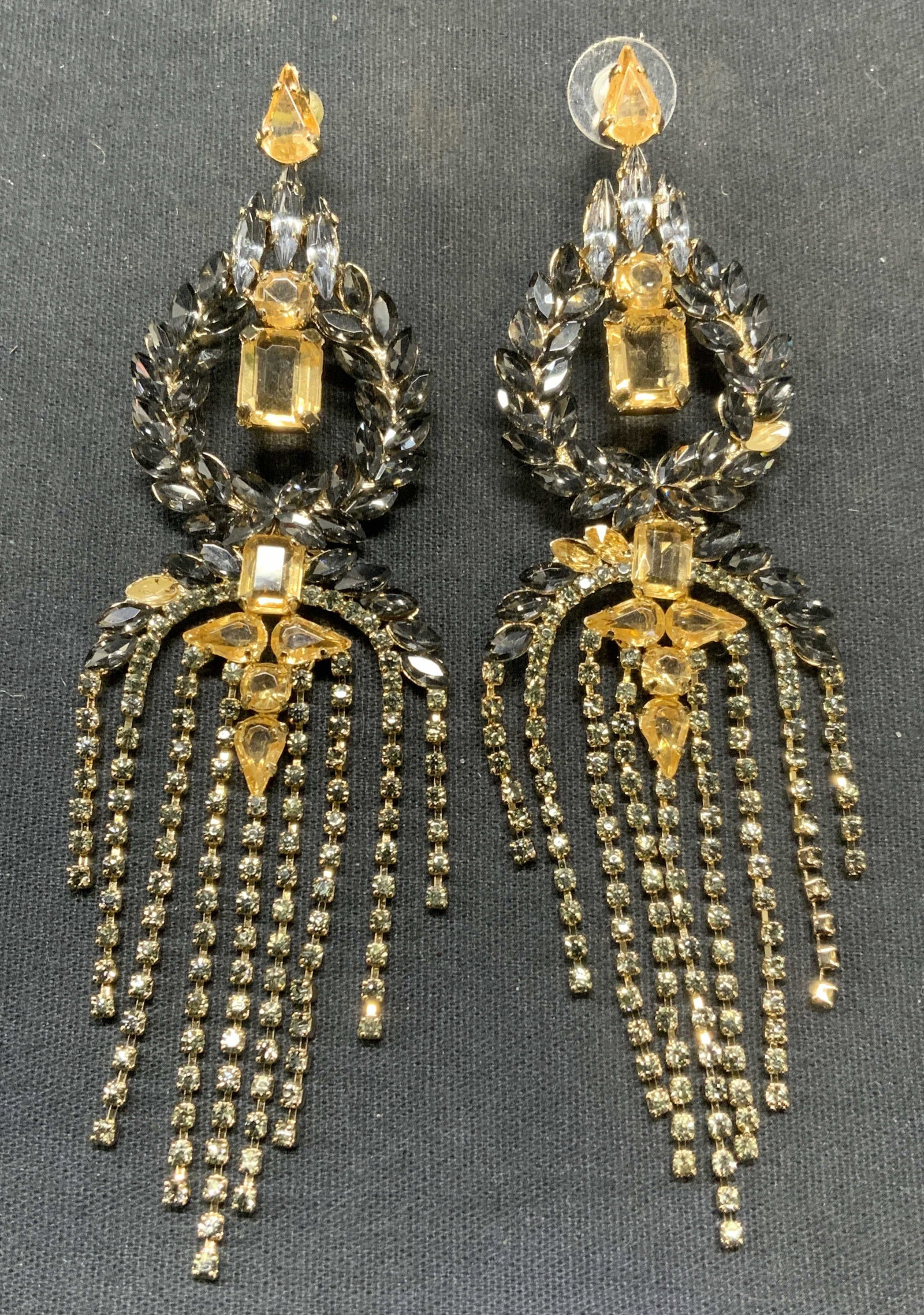 Gold Tn Crystal Chandelier Earrings, 4.75 In: Vintage gold tone crystal chandelier earrings. Smokey gray and amber toned crystal decoration. Post backing. Measure approx. 4.75 x 1.5 inches. Some surface wear including scratching observed. One cry