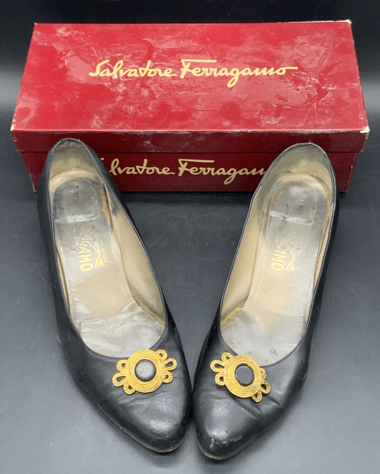 SALVATORE FERRAGAMO Lilian Heeled Shoes, Box: A pair of vintage black leather heeled SALVATORE FERRAGAMO shoes that come in their original red SALVATORE FERRAGAMO box. The shoes have gold tone metal accents to the top of the tips. Interior of sho