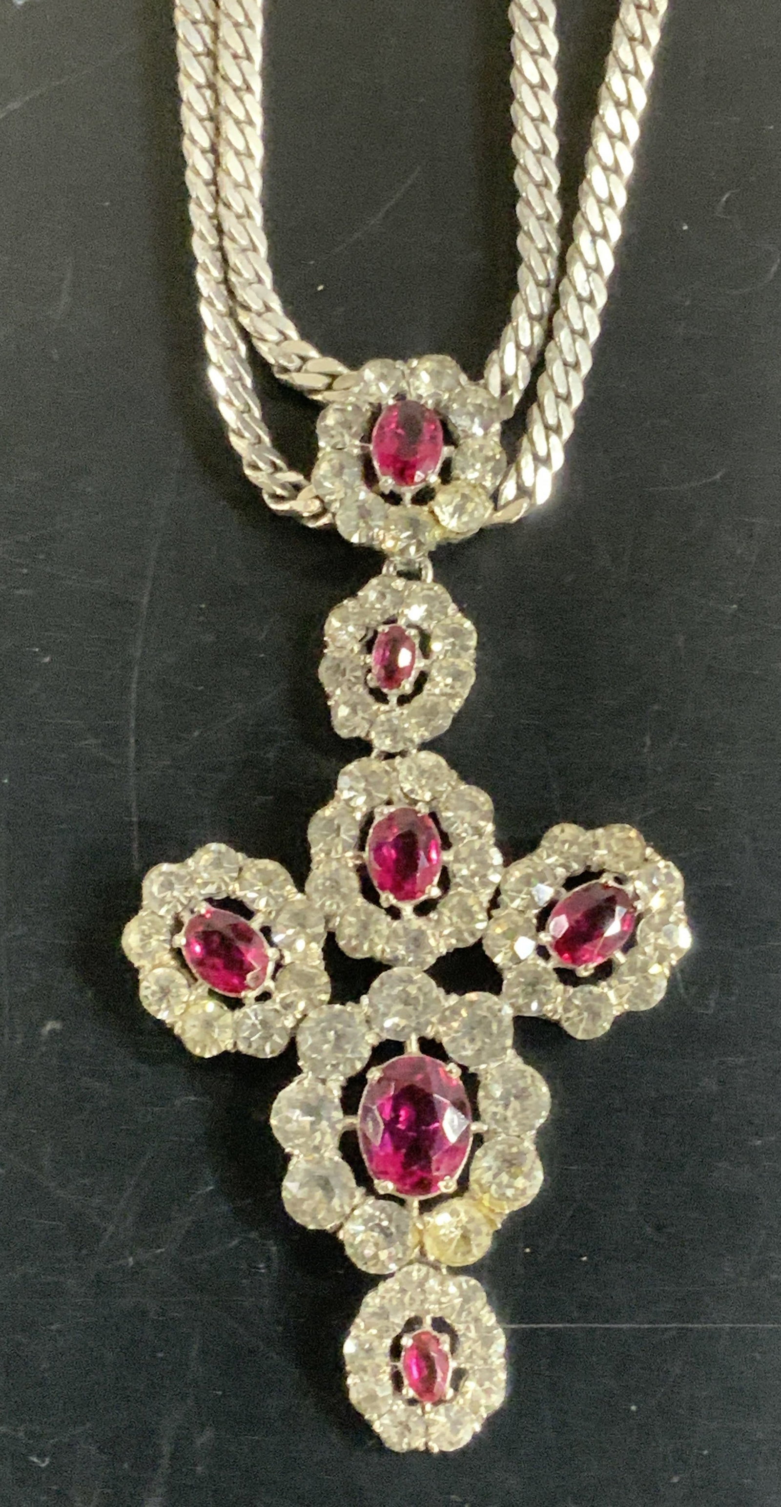 Signed Sterling Silver Crystal Pendant Necklace: Sterling silver pendant necklace with a flat bone chain soldered to a statement crystal pendant with clear and Ruby toned crystals. Signed on backside of pendant, designer illegible, marked sterling. 