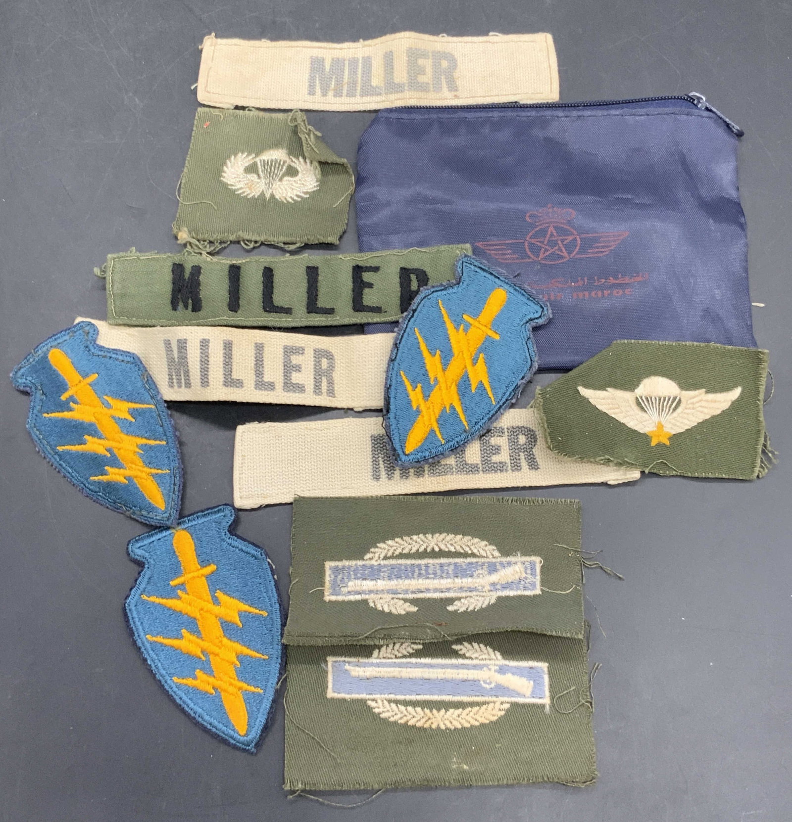 11 Vintage ROYAL AIR MAROC Bag & Fabric Patches: A lot of vintage fabric patches and one ROYAL AIR MAROC zippered travel bag. Patches feature the name MILLER, emblems, crests, and more. ROYAL AIR MAROC zipper travel bag measures approx. 5.25W x 4W i