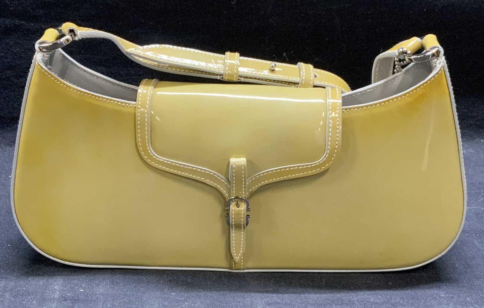 Salvatore FERRAGAMO Patent Leather Handbag, Italy: Salvatore FERRAGAMO beige toned patent leather handbag. Snap button closure with buckle decoration. 1 slip pocket to interior. Signed to interior with serial number. Authenticated by Authentication Fi