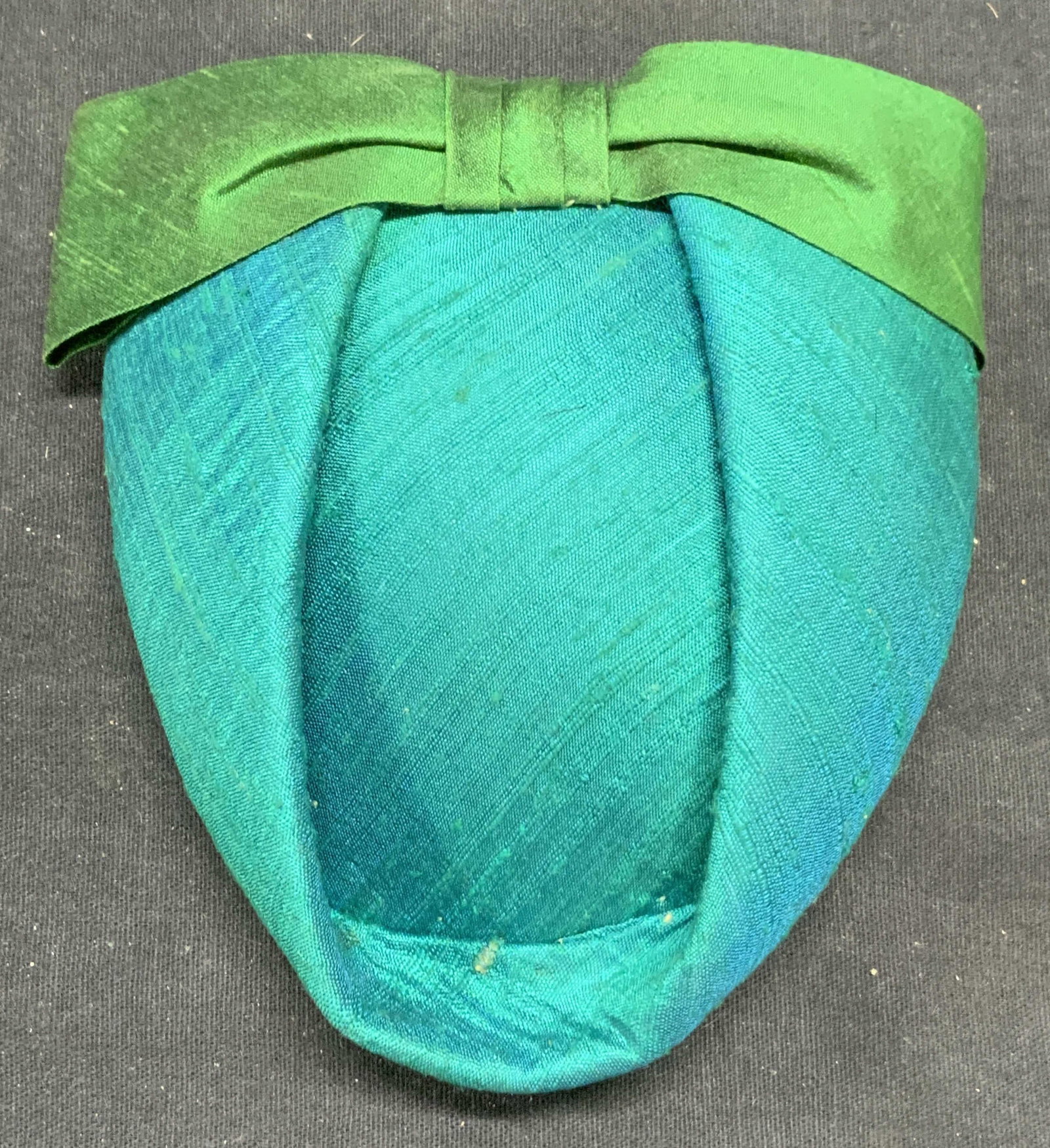 Vintage Teal & Green Bow Fascinator Hair Piece: Vintage teal and green toned fabric covered fascinator hair piece with bow detail. Comb to underside. Measures approx 5 x 4.5 inches. Some wear to material and discoloration to underside observed. Fas