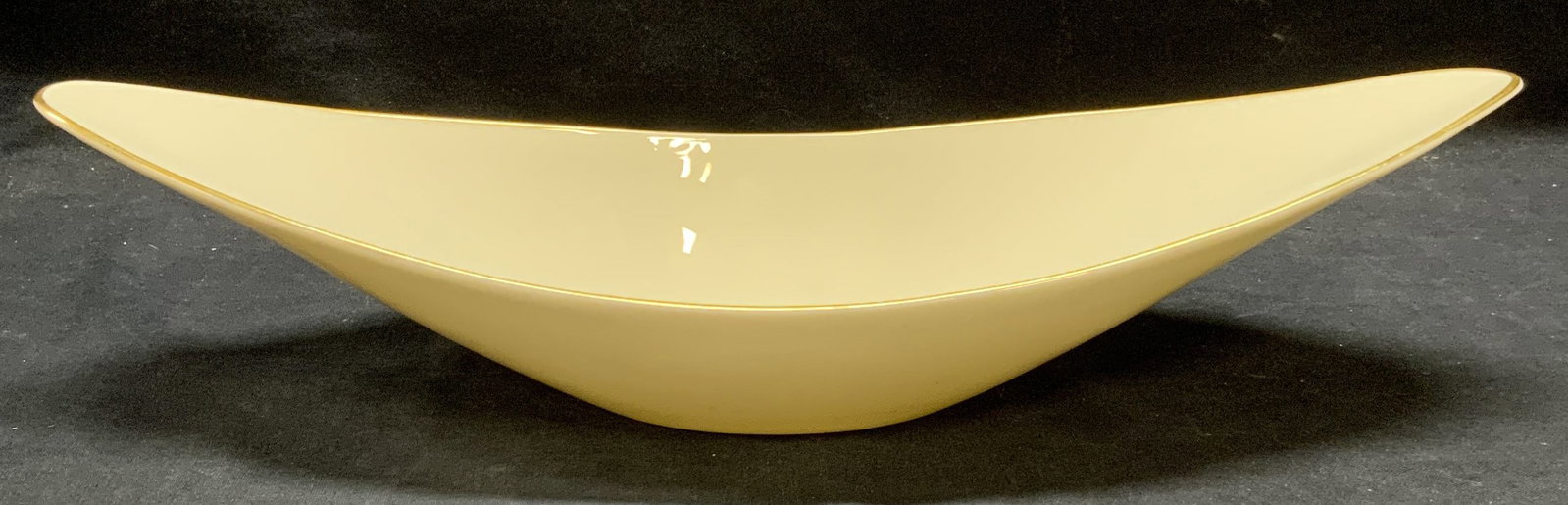 Vintage Lenox Gilt Porcelain Bowl: Vintage Lenox porcelain bowl in cream with gilt rim. Oblong shaped. Trademarked to underside. Measures approx. 15.5 x 5.5 x 3.5 inches. Some surface wear consistent with exposure. Lenox, vintage Lenox