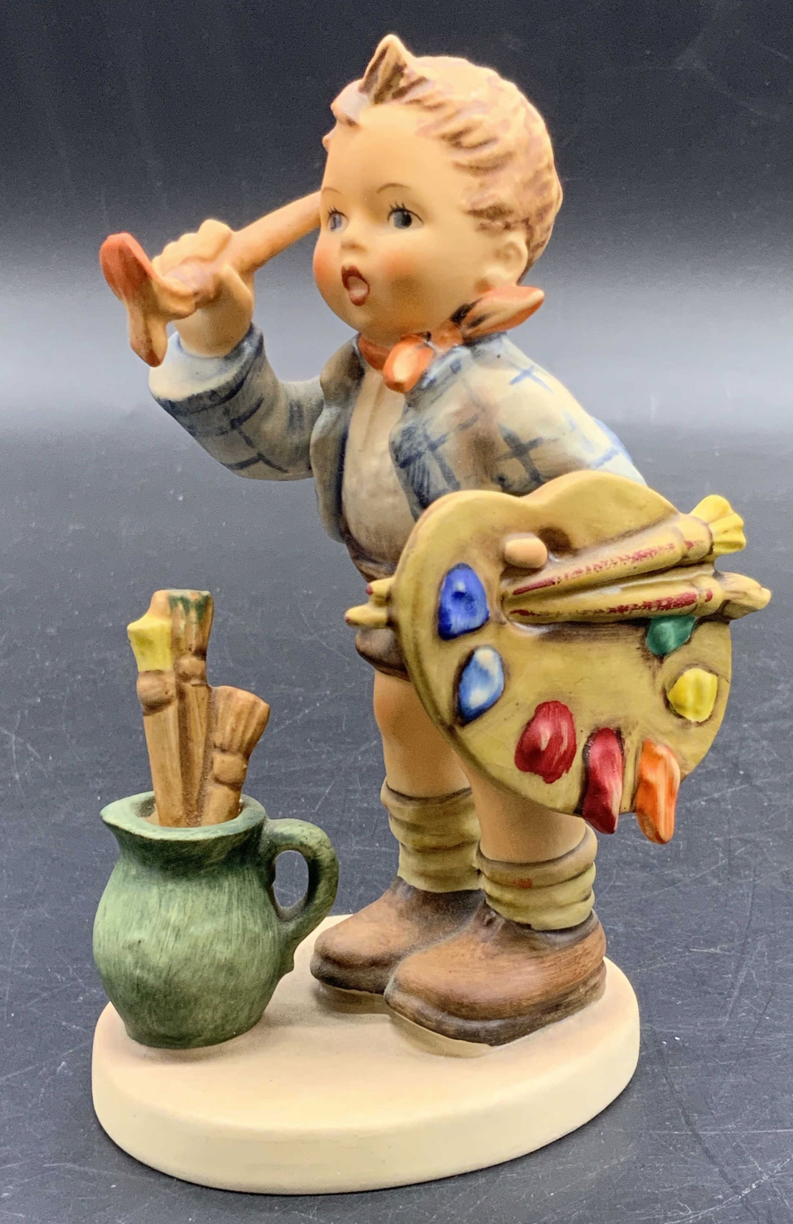 Vintage 1955 Goebel M. J. Hummel The Artist Figural: A Vintage 1955 Goebel M. J. Hummel The Artist Figural crafted from ceramics and signed & dated on underside. Measures approx. 5.25H x 3W in. Some wear consistent with age and use. Some crazing present