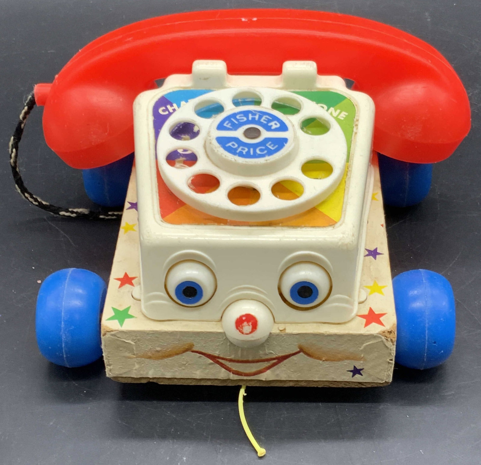FISHER PRICE Vintage Classic Chatter Phone Toy USA: A vintage Classic Chatter Phone by FISHER PRICE. Bright multicolored hues. Wheels, eyes, and dial are moveable. Crafted from wood and composite materials. Measures approx. 3.75H x 7.5W in. Measured at