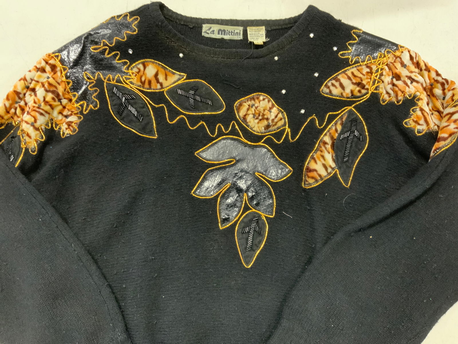 La Mittini Lambswool/ Angora Vtg Sweater, H. Kong: La Mittini vintage Applique black sweater, made in Hong Kong. 70%/30% Lambswool/ angora with nylon. Plush leaf pattern with gold metallic piping outline, faux leather and black beading. Size L. Modera