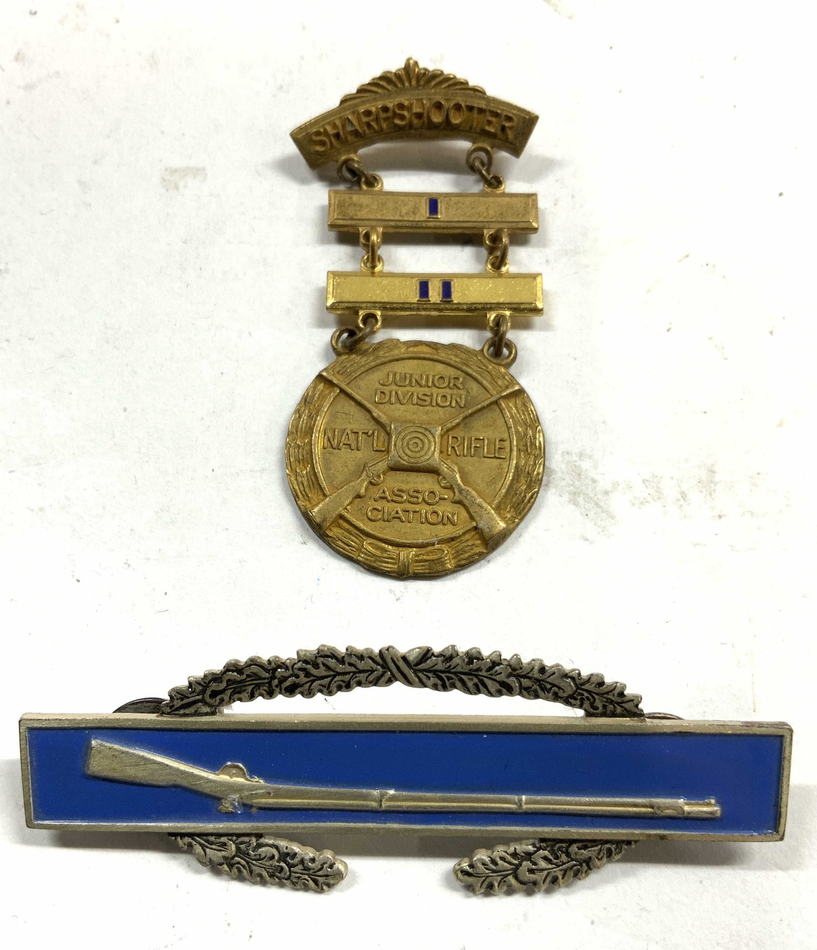 Sterling & Enam Rifle Brooch & Sharpshooter Brooch: Backside of brooch with rifle & blue toned enamel reads STERLING on backside. Other brooch is gold toned with 3 tiers, backside reads BLACKINTON. Front Side reads SHARPSHOOTER JUNIOR DIVISION NATL RIF