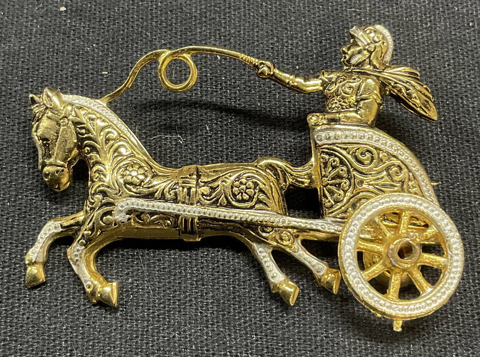 Vintage Gold Tn Damascene Chariot Brooch, Spain: Vintage gold tone damascene chariot brooch. Figure with horse. Ornate embossed detail. Marked Spain to underside. Hinge pin to underside. Measures approx. 2 x 1.5 inches. Includes jewelry box. Some sc