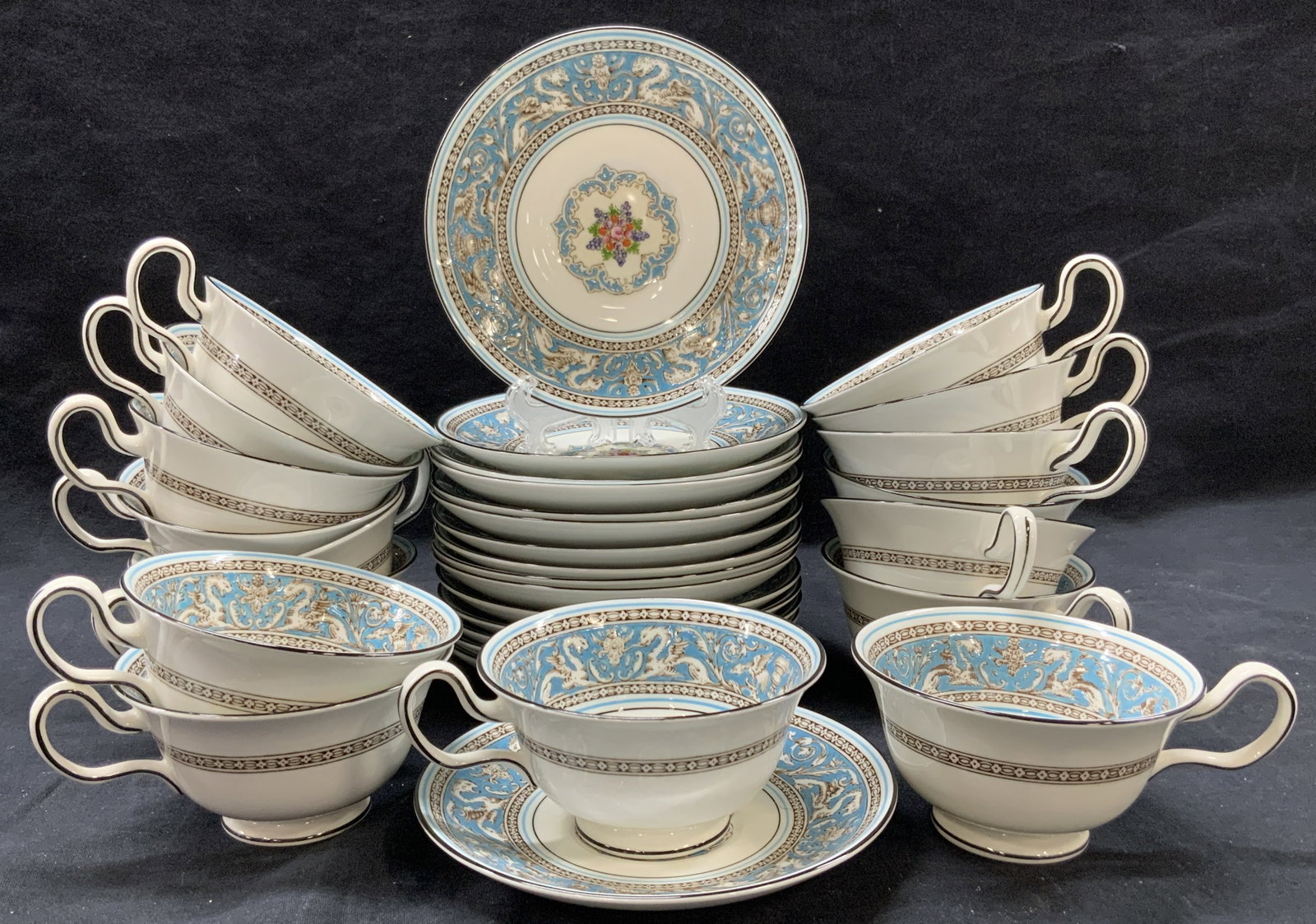 Set32 Wedgwood Bone China Teacups & Saucers: Set of 32 total Wedgwood bone China cups and saucers. 16 cups at 2.25 inches tall and 4 Inch diameter and 16 saucers. All pieces are in the Florentine pattern and have baby blue centers and rims with 